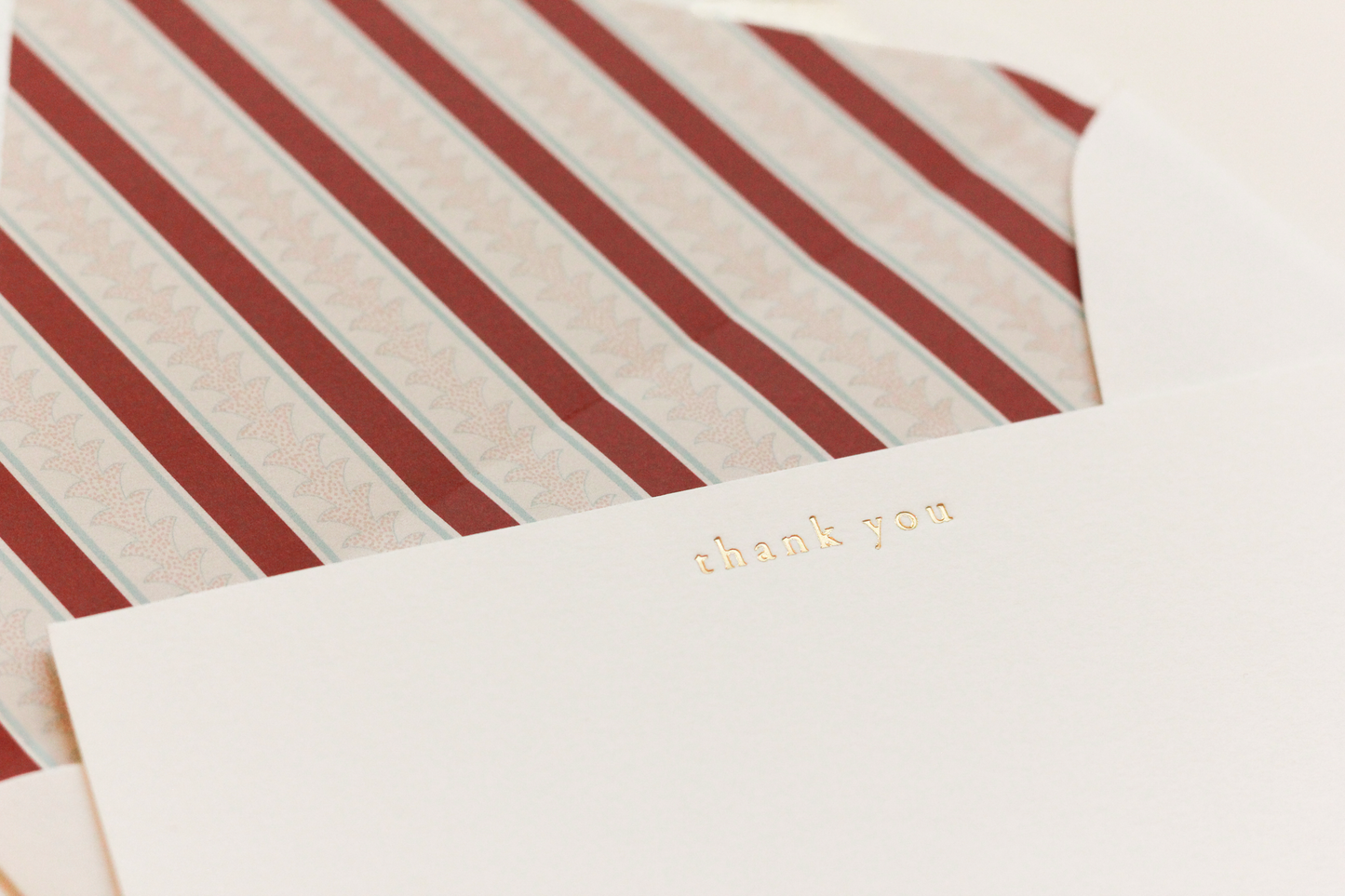 Striped envelope with a 'thank you' card on a matching background